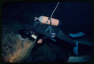 Ron Taylor underwater with orange oxygen tank