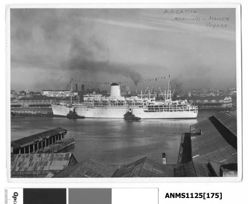 P&O liner ARCADIA dressed with flags and being assisted to her berth by two tug boats on her port side.