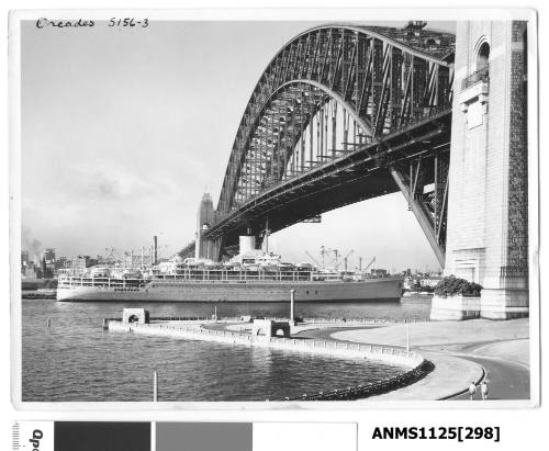 Incoming P&O liner ORCADES is seen here passing under the Sydney Harbour Bridge assisted by a tug with Circular Quay in the background