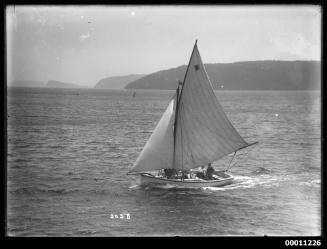 Small gaff--rigged boat sailing on Pittwater.