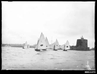 Fleet of 16-foot skiffs sail past Fort Denison on Sydney Harbour