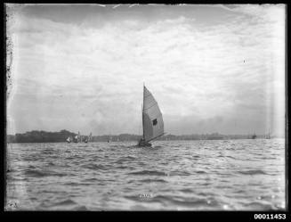 16-foot skiff with shield sail insignia trails the field on Sydney Harbour