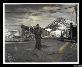 Man posing at McMurdo base in Antarctica, Observation Hill in background