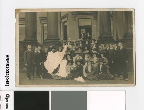 A large group of men and women standing in front of a building with large columns