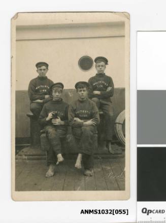 Young crew of the White Star Line on deck with cat