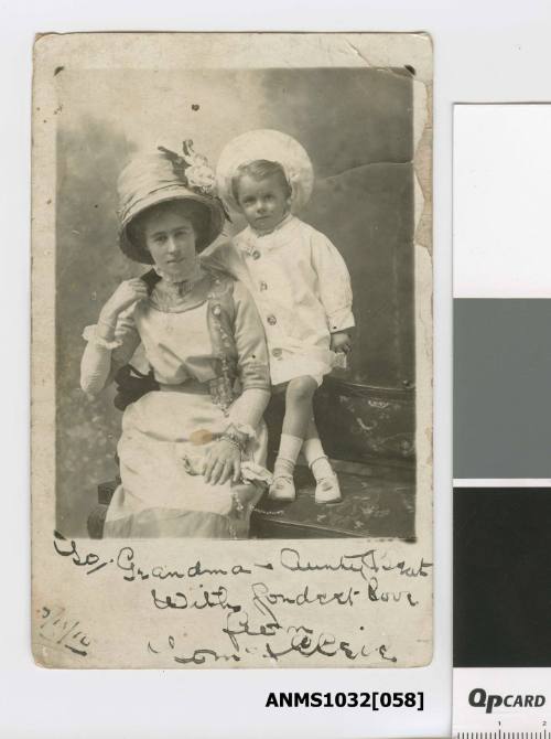 A woman sitting on a chair, with her young son standing on the chair beside her