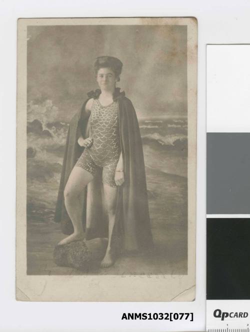 Postcard featuring a black and white photograph of Miss Beatrice Kerr wearing a scallop shaped decorated swimsuit with a long cape