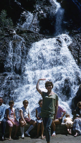 Eve Konrads standing in front of a waterfall with Ilsa Konrads in background