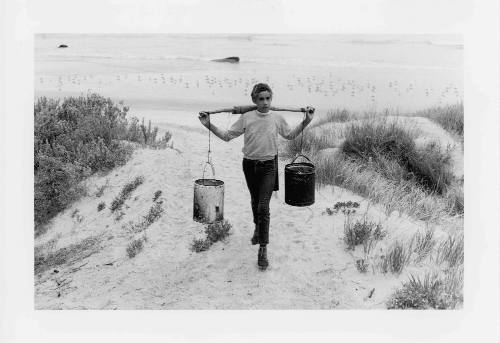 Elliot Maynard carrying a yoke across his shoulder