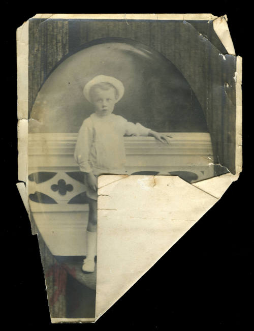 Young boy standing next to a white wall, probably the son of Beatrice Kerr's sister