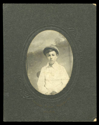 A boy dressed in a white shirt with a cap