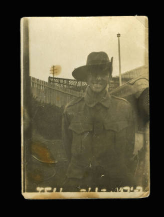 Soldier is army uniform, smiling at the camera