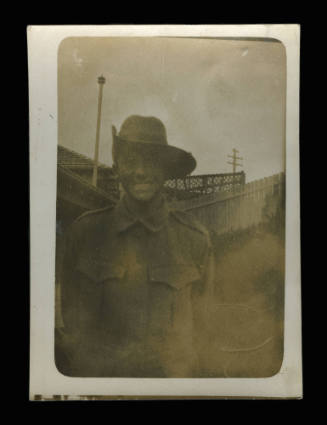 Soldier is army uniform, smiling at the camera