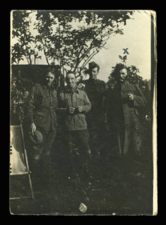 Black and white photograph of four men in army uniform standing in a line