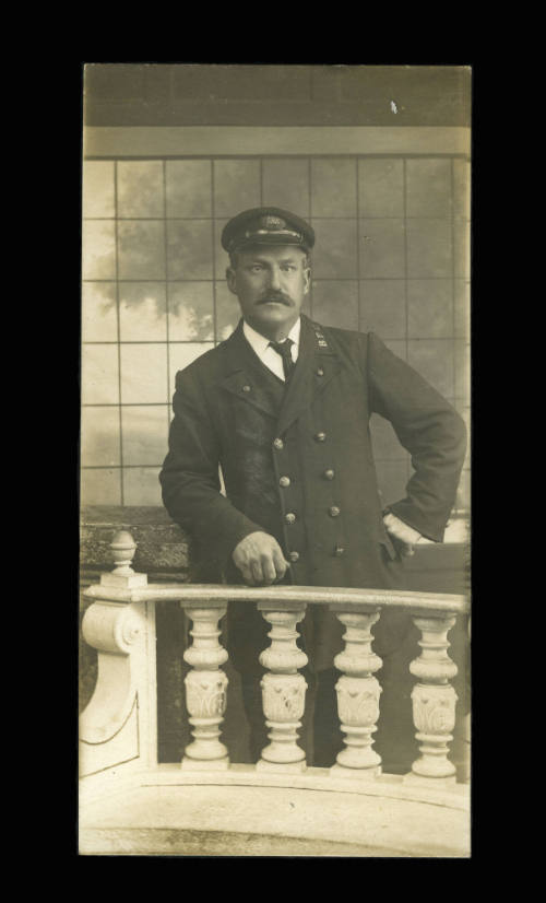 Man in naval uniform, leaning on a balustrade