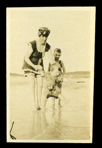Woman, Beatrice Kerr's sister, wearing a swimsuit, with two small children at the beach