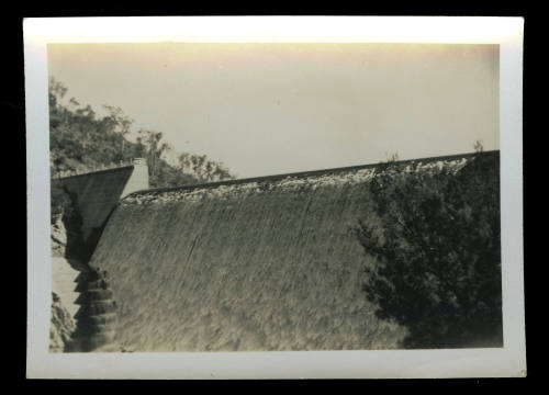 A dam wall with water running down the side of the dam