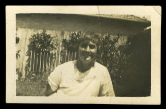 Middle aged woman wearing a white shirt, and smiling at the camera