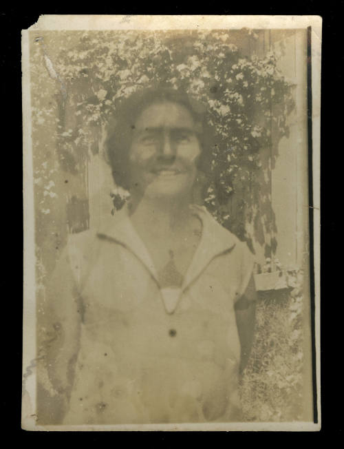 Woman wearing a sleeveless white shirt, smiling at the camera, probably Beatrice Kerr