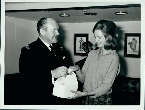 Commodore Edgecombe handing out the 12000th packed lunch box to Miss Jenny Purves of Melbourne to take to the Olympic Games