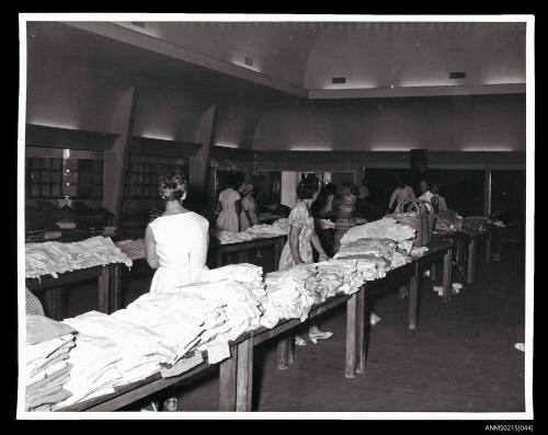 Women folding clothes at a European migrant camp