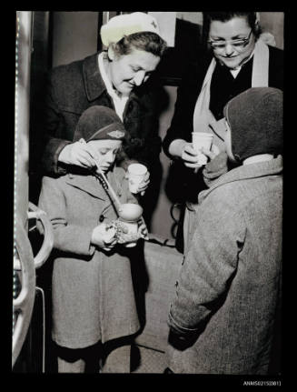 Two migrant children receiving drinks at Salzburg station from Austrian Red Cross workers