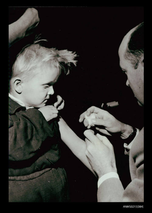 Young boy being prepared for vaccination by doctor