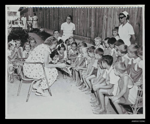 Group of young children at an educational class with teacher at European transit camp