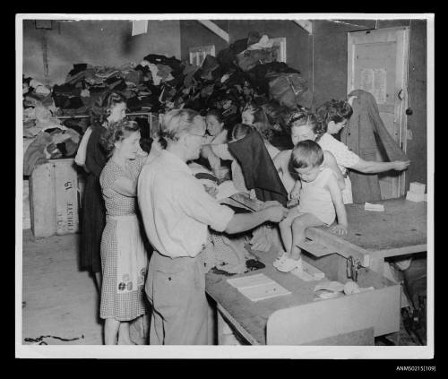 Refugees select clothing from large clothing store, displaced persons camp clothing store Europe