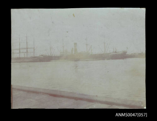 Barque and a steamship docked at a wharf