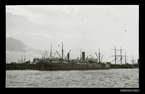 Harbour scene with a steamship docked at a wharf