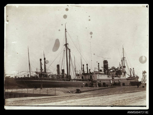 Wharf with a docked steamship taking on cargo