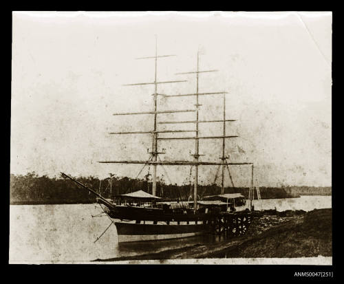 Barque moored at a riverside wharf