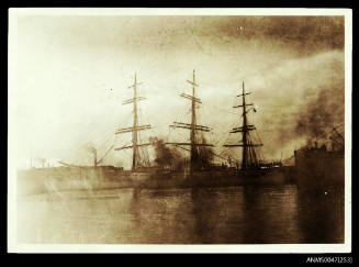 Full-rigged ship at a wharf.