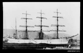 Barque OCEANA docked at a wharf with industrial buildings behind