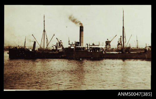 Single funnel cargo steamship underway with a tug boat