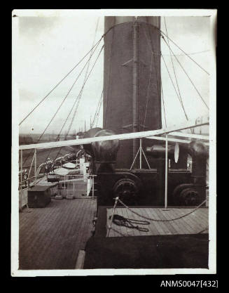 View of the lower part of a ship's funnel and ventilators facing aft