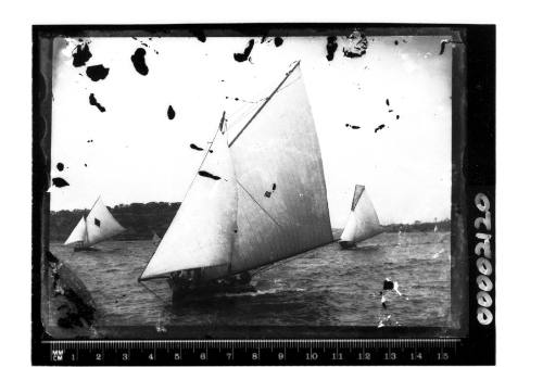 Three open boats on Sydney Harbour, the vessel in the foreground has '63' on the mainsail and the vessel on the left displays a diamond