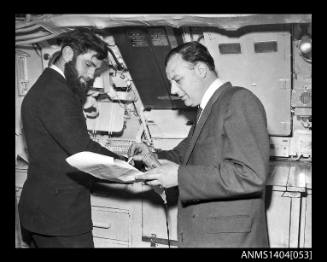 Civilian man interviewing a Royal Navy officer on HMS ANCHORITE