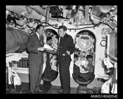 Civilian man interviewing a Royal Navy officer on HMS ANCHORITE