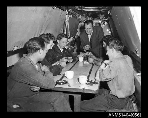 Civilian man interviewing crew members on HMS ANCHORITE