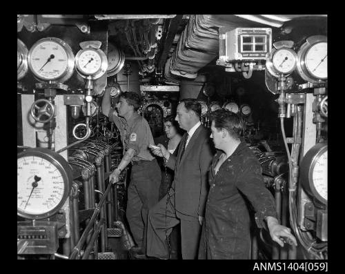 Civilian man interviewing crew members on HMS ANCHORITE