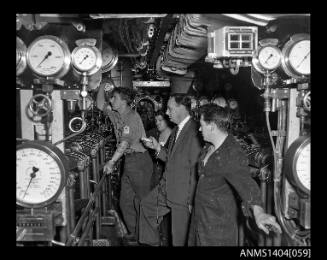Civilian man interviewing crew members on HMS ANCHORITE
