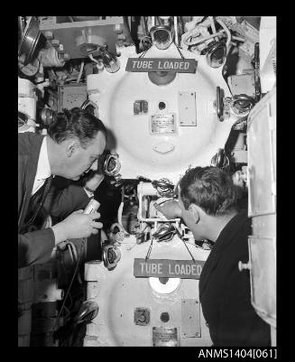 Civilian man interviewing a crew member on HMS ANCHORITE