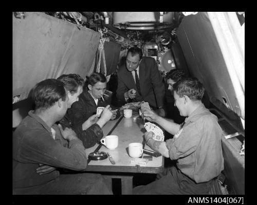 Civilian man interviewing crew members on HMS ANCHORITE