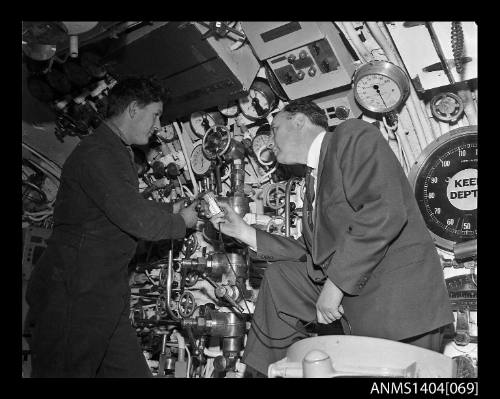 Civilian man interviewing a crew member on HMS ANCHORITE