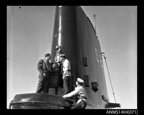 Civilian man interviewing a Royal Navy crew member on HMS ANCHORITE