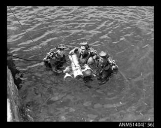 Photographic negative showing divers testing an AWA underwater television camera