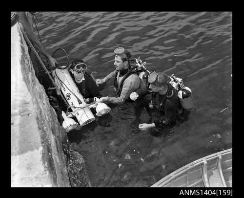 Photographic negative showing divers testing an AWA underwater television camera