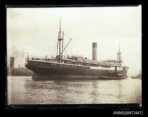 TSS KATOOMBA being guided by three tugboats in a harbour